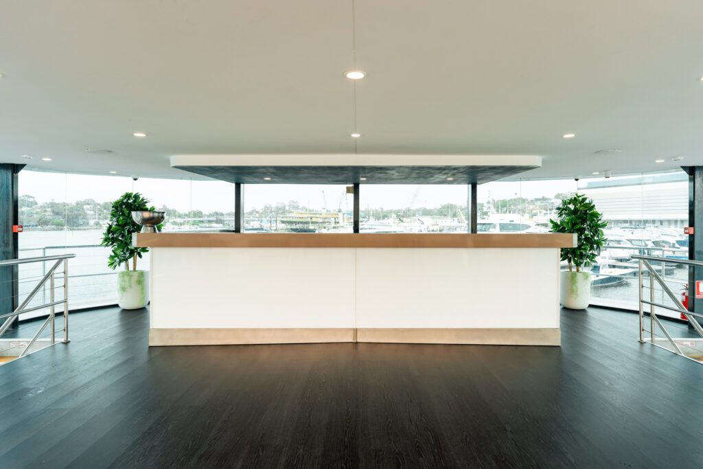 Luxurious yacht interior with sleek bar and panoramic harbor views.