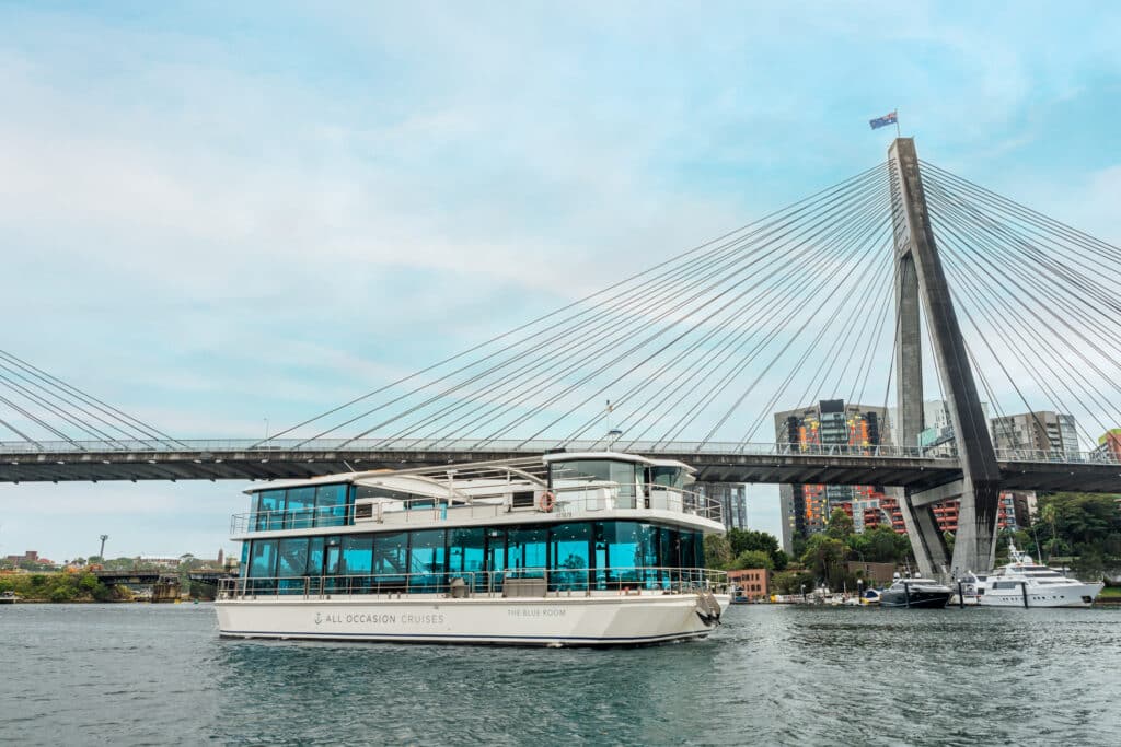 Luxury yacht cruising under Sydney's elegant cable-stayed bridge.