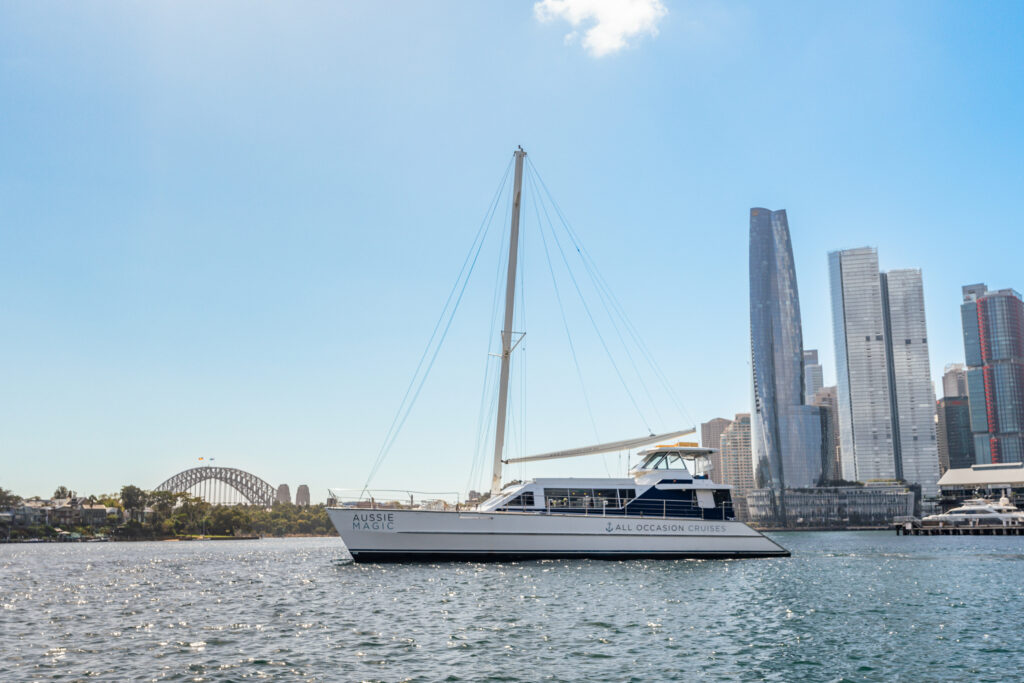 Luxury yacht cruising in Sydney Harbour with skyline and bridge views.