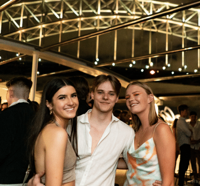 Three smiling friends enjoy an evening on a Pyrmont cruise.