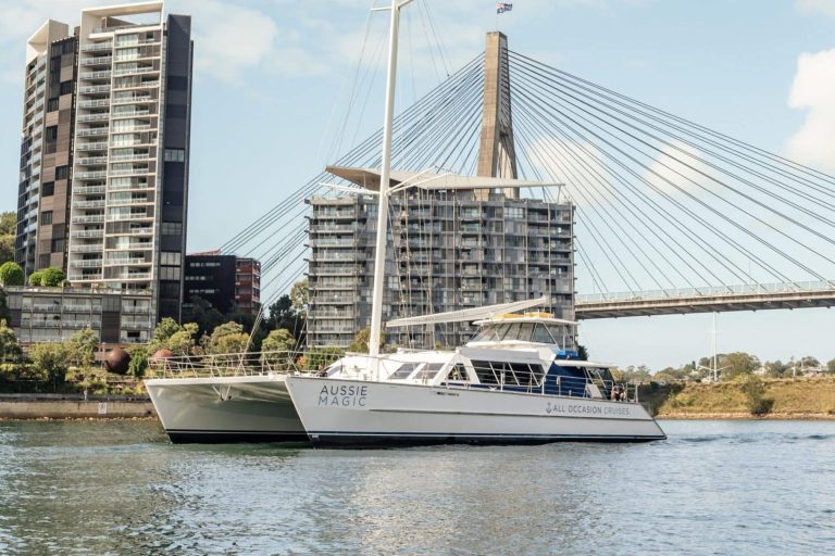 Luxury charter yacht sailing beneath Sydney's iconic Anzac Bridge.