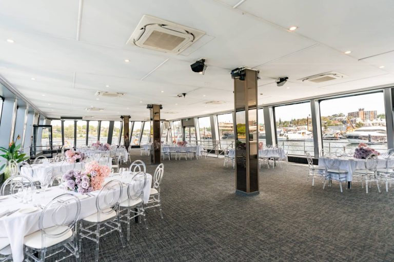 Spacious dining area on a cruise ship with waterfront views and elegant decor.