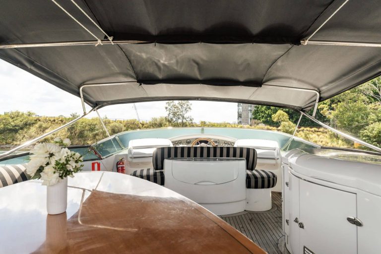 Luxurious interior view of a Pyrmont cruise boat with a wooden table and flowers.