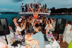 University students dancing and enjoying a lively party on the upper deck of a boat.
