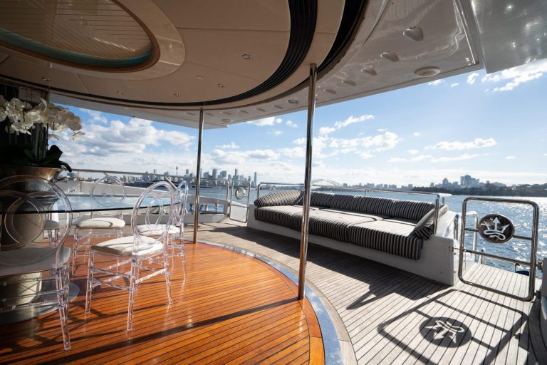 Luxury yacht deck with seating facing stunning city skyline views.